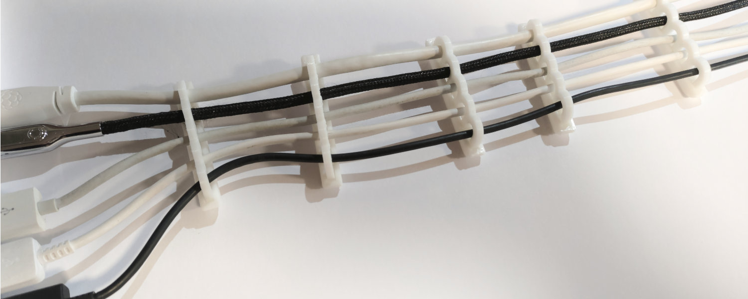 A close-up of a cable featuring several attached wires, all combed into lines with cable combs