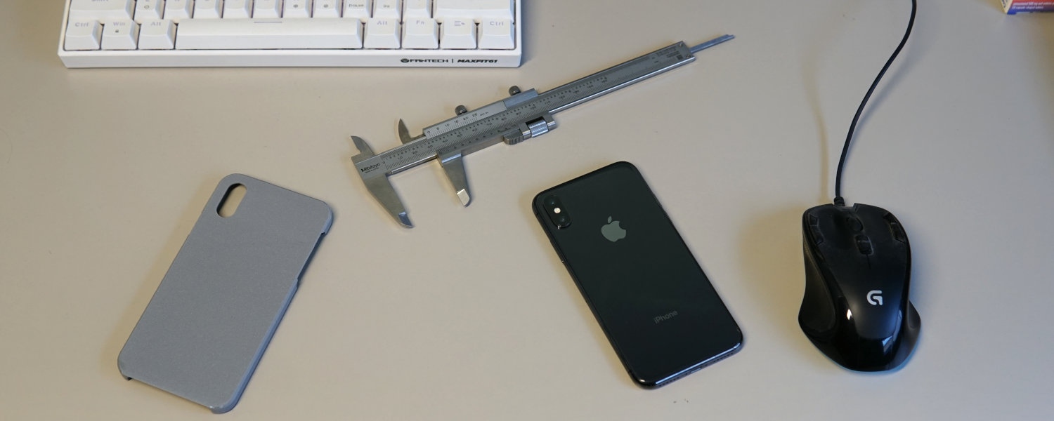 A desktop scene featuring a mouse, keyboard, iPhone, anf 3D printed case, reverse engineering and product design.